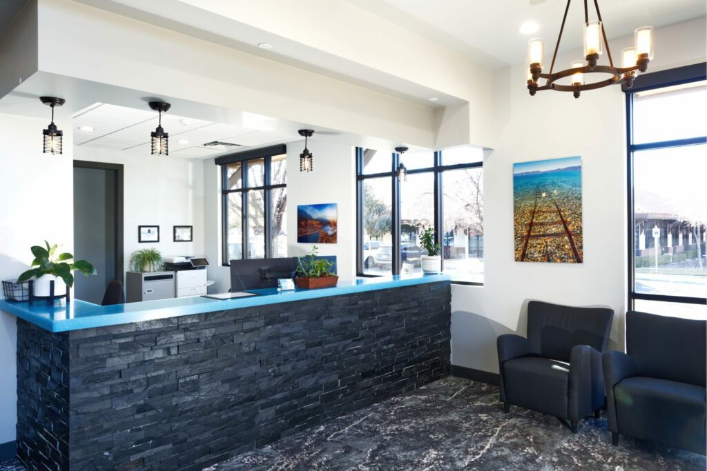 A waiting room space with a dark brick counter and white walls.